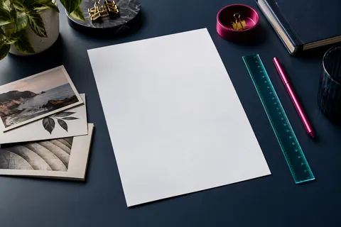 Feuille de CV vierge, cartes et règle cyan sur un bureau bleu nuit