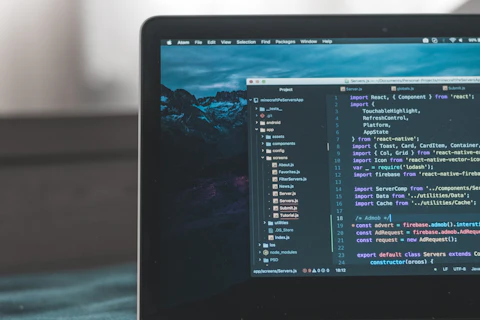 Ordinateur portable affichant du code sur un bureau sombre